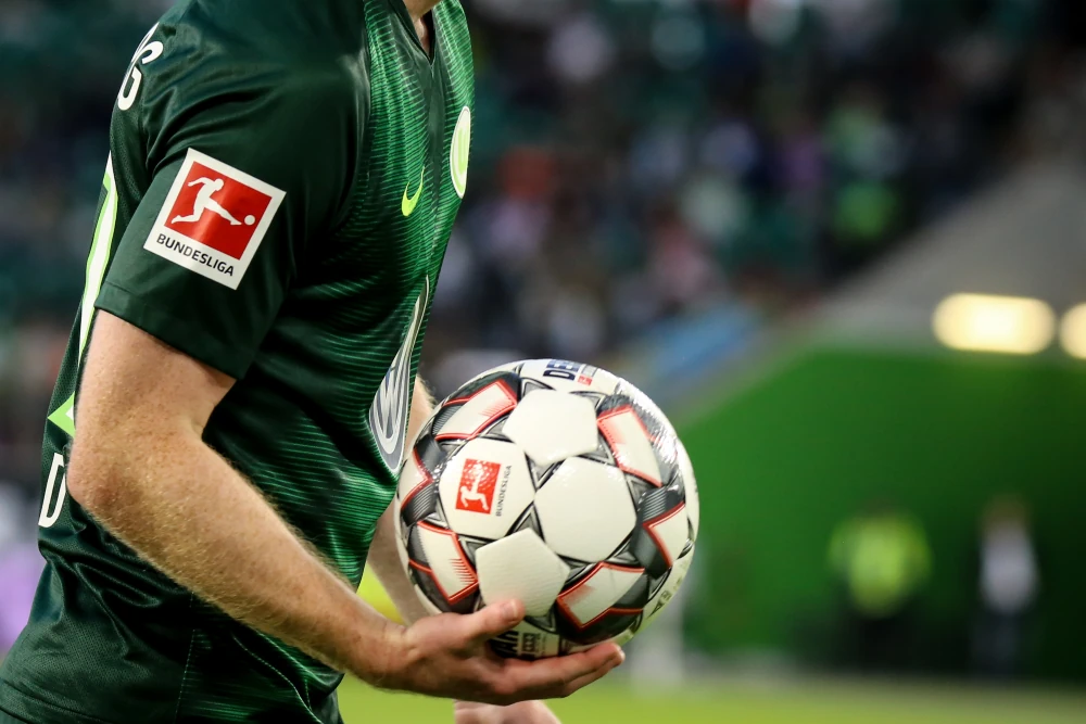 Logo della Bundesliga sulla maglia di un giocatore e il pallone nelle sue mani