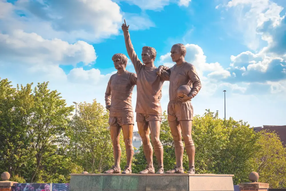 La statua di George Best, Denis Law (al centro) e Sir Bobby Charlton